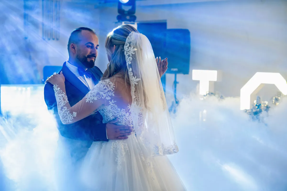 Brudparet dansar sin första dans i dimma och blått ljus